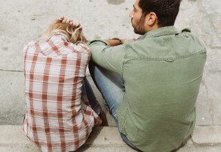 man-and-woman-sitting-on-sidewalk man-and-woman-sitting-on-sidewalk