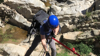 Andrew rappelling down Ortega Falls route