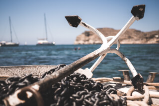 white-and-black-anchor-with-chain-at-daytime