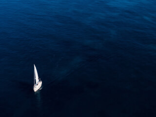 white-boat-sailing-on-body-of-water
