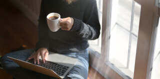 woman-using-laptop-while-holding-a-cup-of-coffee woman-using-laptop-while-holding-a-cup-of-coffee